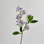 Artificial jasmine floral sprig with delicate white and purple blossoms on green leaves.