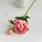 Artificial silk peonies with leaves arranged on a clean white background for home decor.