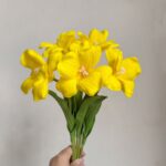 Yellow real touch tulip bouquet with open blooms held in hand