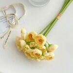 Silk yellow rose bouquet with decorative patterned ribbon accents, ready for gifting or decor.