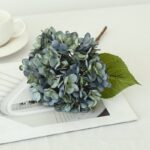 Realistic silk hydrangea bouquet featuring dusty blue and gray florets on white background