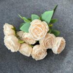 Artificial cream silk roses bouquet with lush green foliage for everlasting decor.