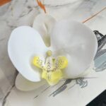 Realistic 3D artificial white silk orchid flower head used for elegant home floral decor.