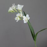 Artificial flower arrangement of white Freesia blossoms on a realistic stem.