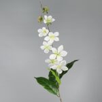 Artificial flower branch of white silk crabapple blossoms on green leaves.