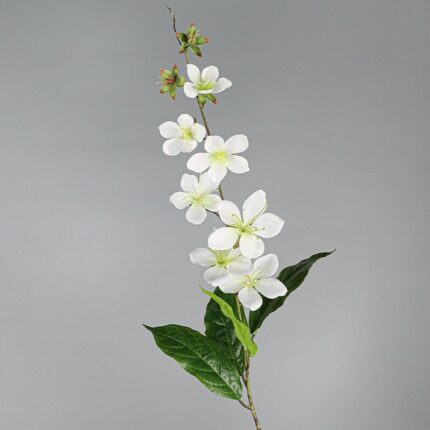 Artificial flower branch of white silk crabapple blossoms on green leaves.