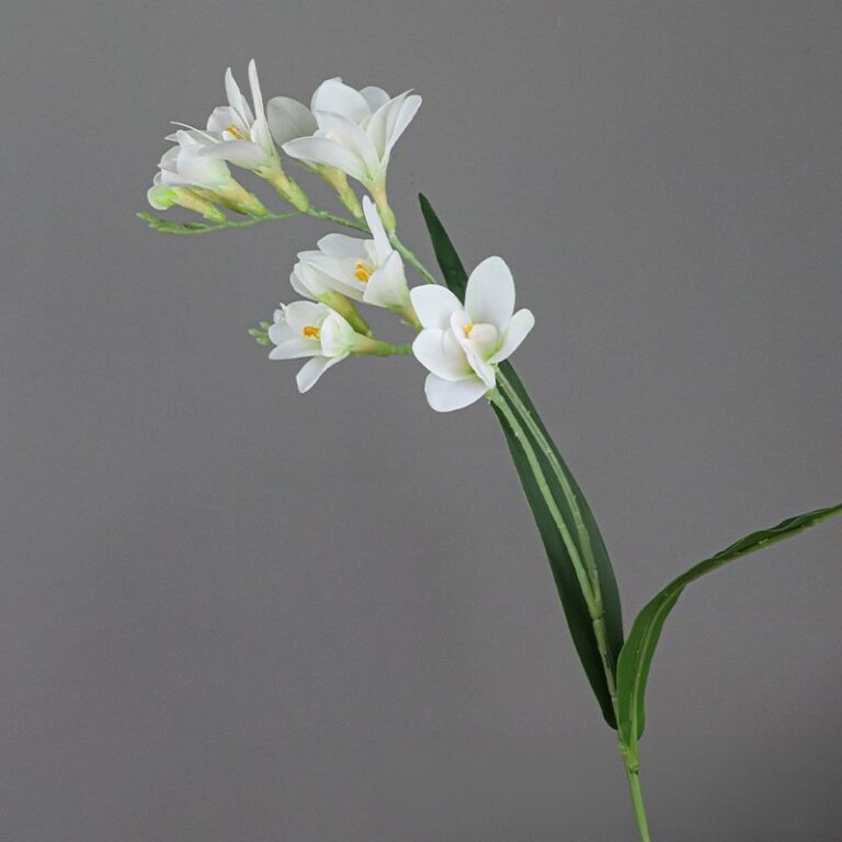 Artificial flower arrangement of white Freesia blossoms on a realistic stem.