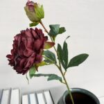 Two deep maroon silk peony artificial flowers with foliage for home decor.