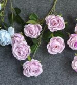 Cluster of pink silk artificial roses on green foliage, perfect for home decor.