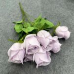 Bundle of lilac silk roses artificial flower bouquet with green foliage.