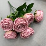 Cluster of artificial pink silk roses with green leaves for home or event decor.