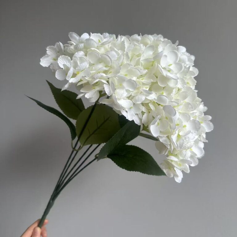 White silk hydrangea bouquet with green leaves