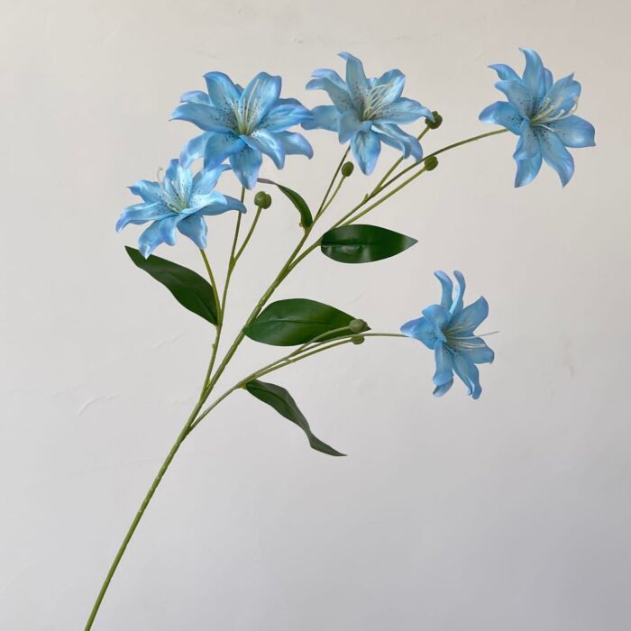 Branch of faux blue lilies, a realistic artificial flower perfect for wedding decorations.