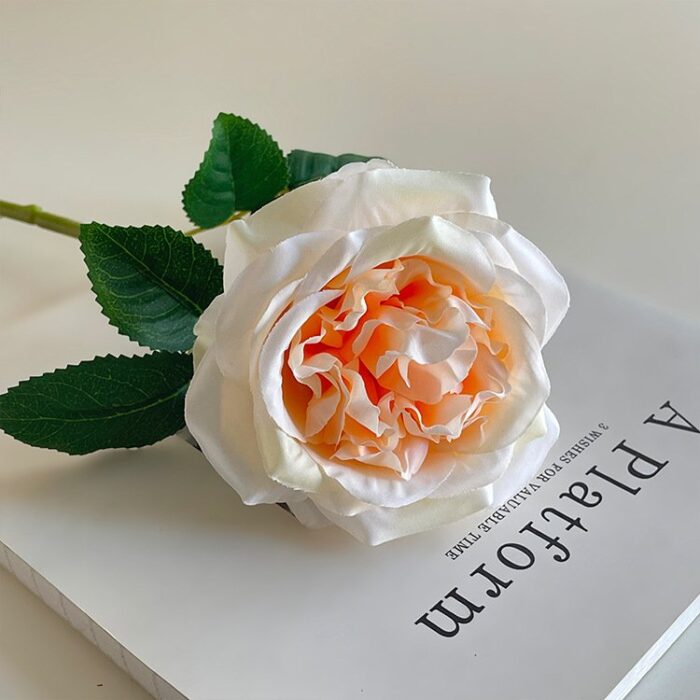 Beautiful silk rose bloom with green leaves, ideal faux wedding flowers decoration.