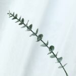Realistic faux eucalyptus sprig, ideal for wedding bouquets and decor.