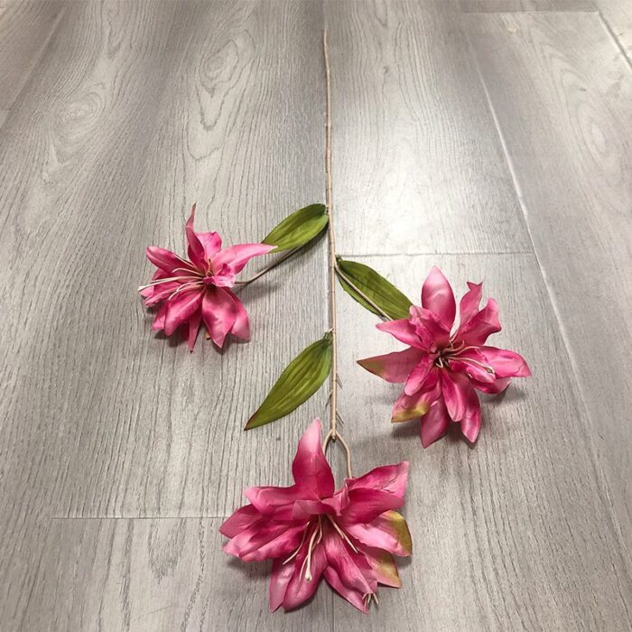 Three realistic pink silk lily blooms perfect for faux wedding flowers decor on a wood floor.