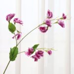 Realistic faux sweet pea flower arrangement with green leaves, perfect for wedding decor.