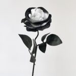 Artificial silk rose with dark petals and white center, perfect for faux wedding decor.