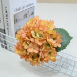 Artificial hydrangea bouquet in peachy apricot tones for home decor.